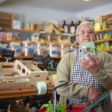 Mână care ține un produs alimentar în supermarket, cu eticheta nutrițională la vedere