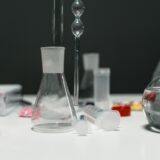Eprubete și vase de laborator așezate pe o masă de lucru, pregătite pentru un experiment